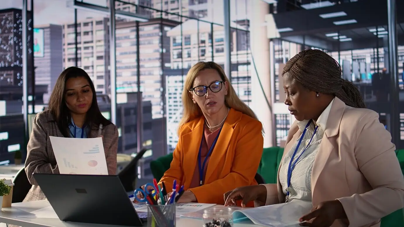 Амбициозные женщины-руководители, сотрудничающие в разнообразной рабочей среде.